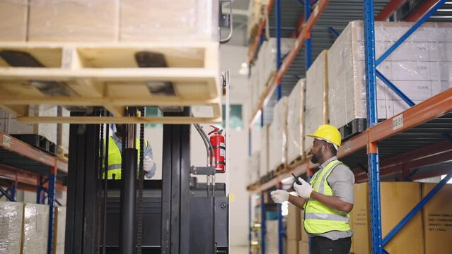 Warehouse worker on a forklift getting the load down