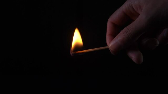 Man lights a match in total darkness