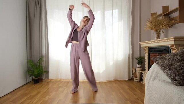 Energetic, athletic woman dancing at home. Active and joyful perception of life.
