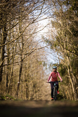 Pretty, young woman with her mountain bike going for a ride past the city limits, getting the daily cardio dose - close-up portrait