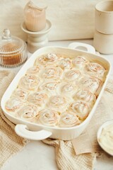 Vertical shot of delicious cinnamon Buns with cream on a white table