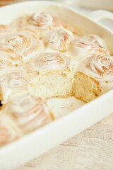 Vertical shot of delicious cinnamon Buns with cream on a white table