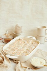 Vertical shot of delicious cinnamon Buns with cream on a white table