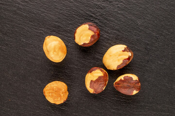 Roasted hazelnuts  on slate stone, macro, top view.
