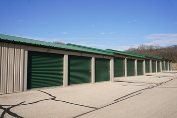 Green and white storage units being used to hold rental property and belongings.