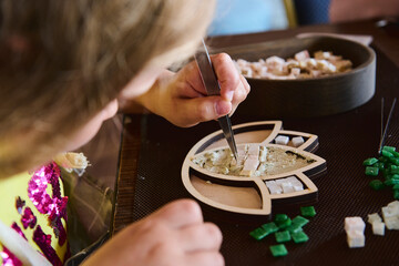 person assembles a mosaic