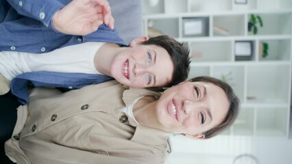 pov, mother and son are talking to their relatives looking into the front camera of a smartphone. Mom with child speaking with father or family making a video call webcam view vertical video shot - Powered by Adobe