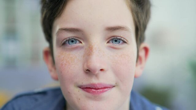 Portrait funny teenage schoolboy with freckles and braces with blue eyes smiling looking at camera at home or classroom indoors. Closeup Red-haired cheerful school boy, happy smiling Headshot Close up