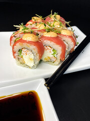 sushi and rolls on the white Japanese plate on black background