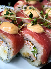 sushi and rolls on the white Japanese plate on black background