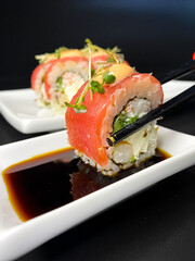 sushi and rolls on the white Japanese plate on black background