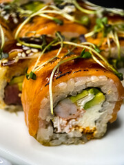 sushi and rolls on the white Japanese plate on black background