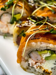 sushi and rolls on the white Japanese plate on black background