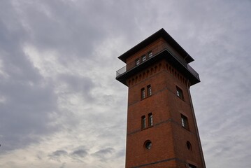 Fototapeta na wymiar Low angle of a brick tower on a cloudy background