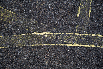 traces de peinture sur une route de bitume abimé par le temps