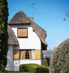 Maison en toit de chaume sur fond de ciel bleu