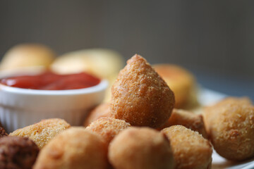 Salgadinhos ou Salgados. Comida Brasileira. Coxinha de frango com ketchup. 