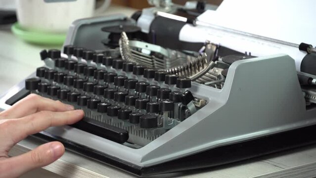 Writing a book and typing old typewriter, top view. Man typing on old vintage retro typewriter. News, media or communication concept