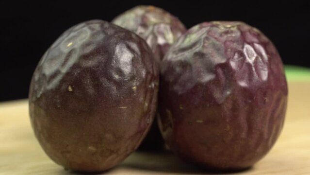 Passion Fruit Rotating on Wooden Cutting Board. Fresh Exotic Maracuya, Healthy Eating, Raw Food, Veganism and Vegetarianism