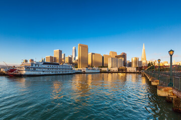 Fototapeta na wymiar Large boat at harbor with cityscape in the background in San Francisco, California