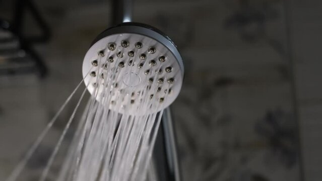 Water flows from the shower sprinkler in a powerful stream, close plan
