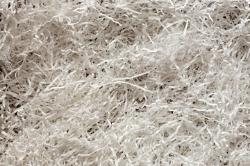 Texture of white paper filler. Background of shredded and cut paper. Filler for transportation and gift wrapping