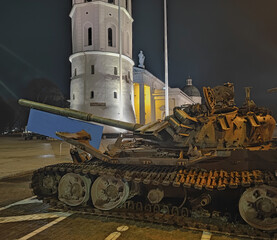 A destroyed Russian tank standing at night in the old town of Vilnius. Battle tank destroyed during...