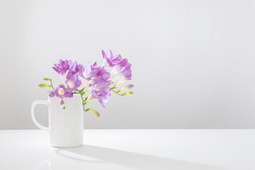purple freesia in glass vase on white background