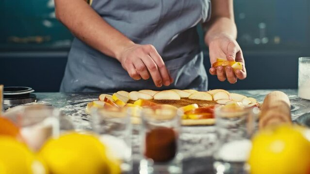 Laying apples on the dough for making a homemade cake. A woman is preparing to bake an apple pie at home. Delicious pastries. High quality 4k footage