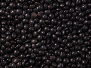 Black lentils texture food background. Dry beluga lentil grains pattern, raw dal, daal, dhal,...