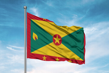 Grenada national flag cloth fabric waving on beautiful sky Background.