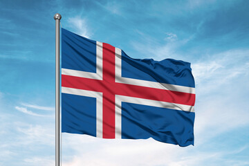Iceland national flag cloth fabric waving on beautiful sky Background.