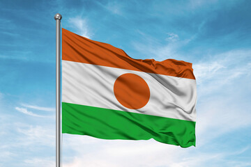 Niger national flag cloth fabric waving on beautiful sky Background.