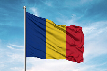 Romania national flag cloth fabric waving on beautiful sky Background.