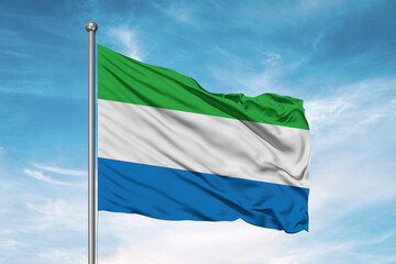 Sierra Leone national flag cloth fabric waving on beautiful sky Background.