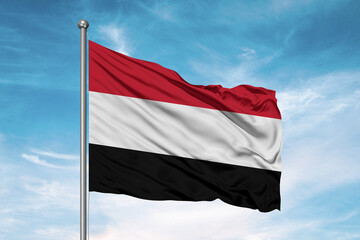 Fototapeta na wymiar Yemen national flag cloth fabric waving on beautiful sky Background.
