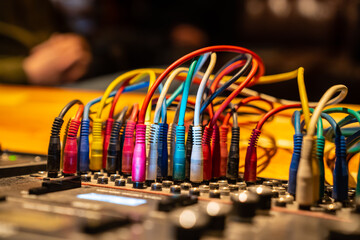 Colorful cables plugged in sound mixing console in recording studio