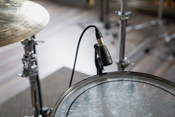 Fototapeta na wymiar Drum recording microphone attached to a side of drum head in recording studio