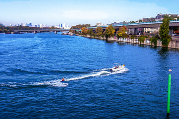A man water skiing  in October on the Seine River - Paris.