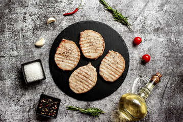 Obraz na płótnie Canvas grilled pork steaks on stone background 