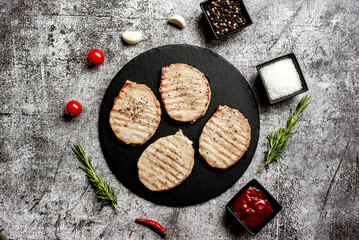 grilled pork steaks on stone background 