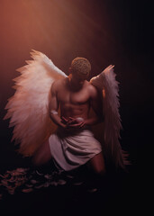 Young strong angel with white wings from heaven. Angel with muscular body. Sensual man