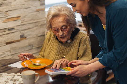 Young Nurse Taking Care Of An Elderly Woman.