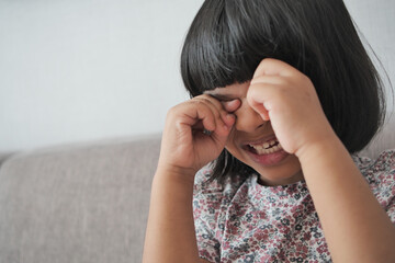 a upset child girl cover her face with hand 
