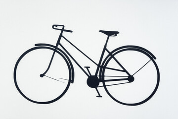 machine cut paper glyph or dingbat of a bicycle isolated on a white backlit surface