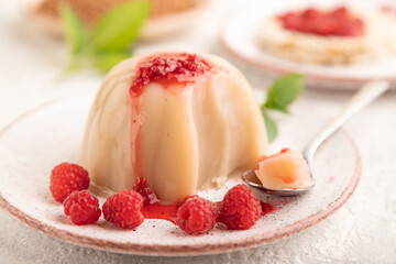 Buckwheat milk jelly with raspberry jam on gray concrete, side view, selective focus.