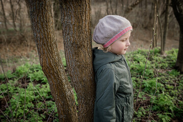 energy of tree: girl charged with positive energy of tree, feeling interaction with nature and support from environment