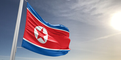 Korea, North national flag cloth fabric waving on beautiful sky grey Background.