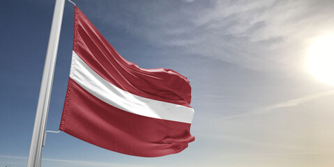 Latvia national flag cloth fabric waving on beautiful sky grey Background.