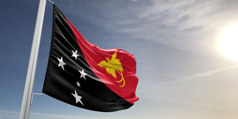 Papua New Guinea national flag cloth fabric waving on beautiful sky grey Background.